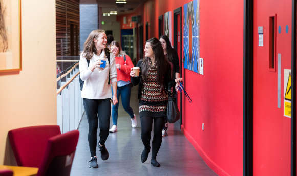 A couple of students walking down the corridor at ֱ Edinburgh