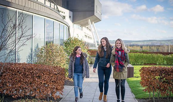 3 girls in winter jackets outside the ֱ Campus, Edinburgh