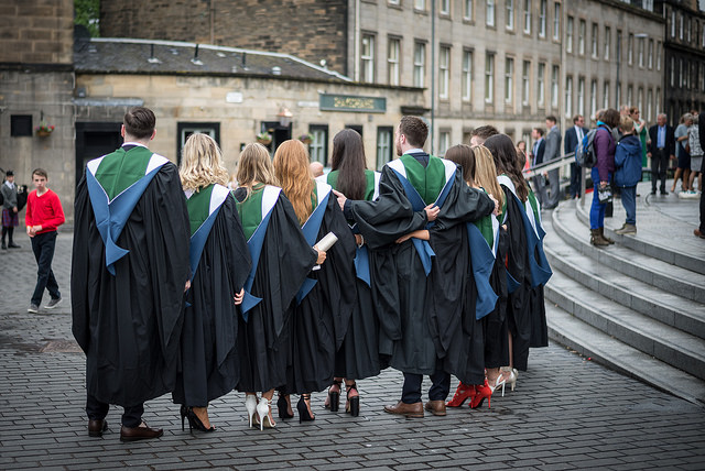 A row of ֱ graduands standing in a row wearing their gowns outside Usher Hall